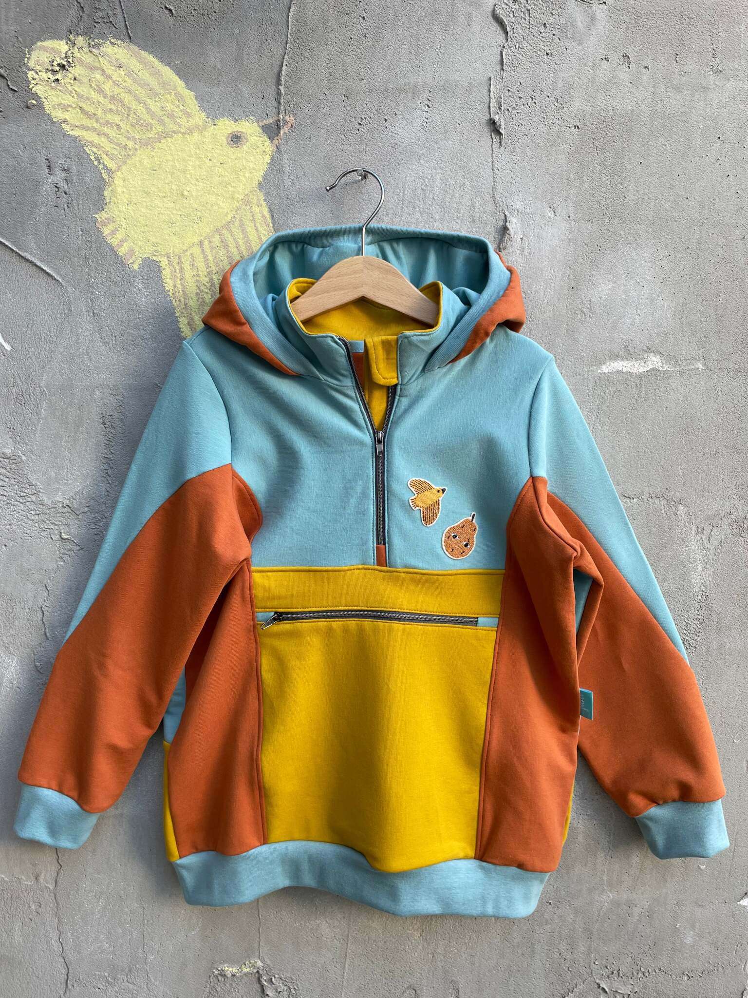 hokuskrokus aus french terry von kattun stoffe verziert mit unseren bügelflicken, die man einfach aufbügelt oder als Aufnäher verwenden kann. Der Pulli ist ocker blau und gelb und mit Vogel und Birnen Patch verziert