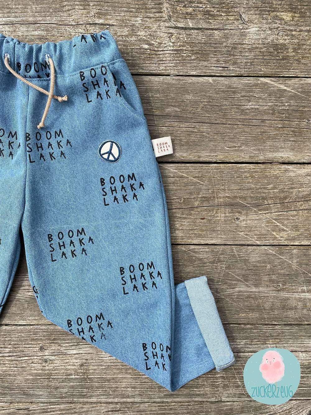 selbstgenähte Jeans hose mit einem boom shaka laka print und einem Aufnäher peace auf der Tasche