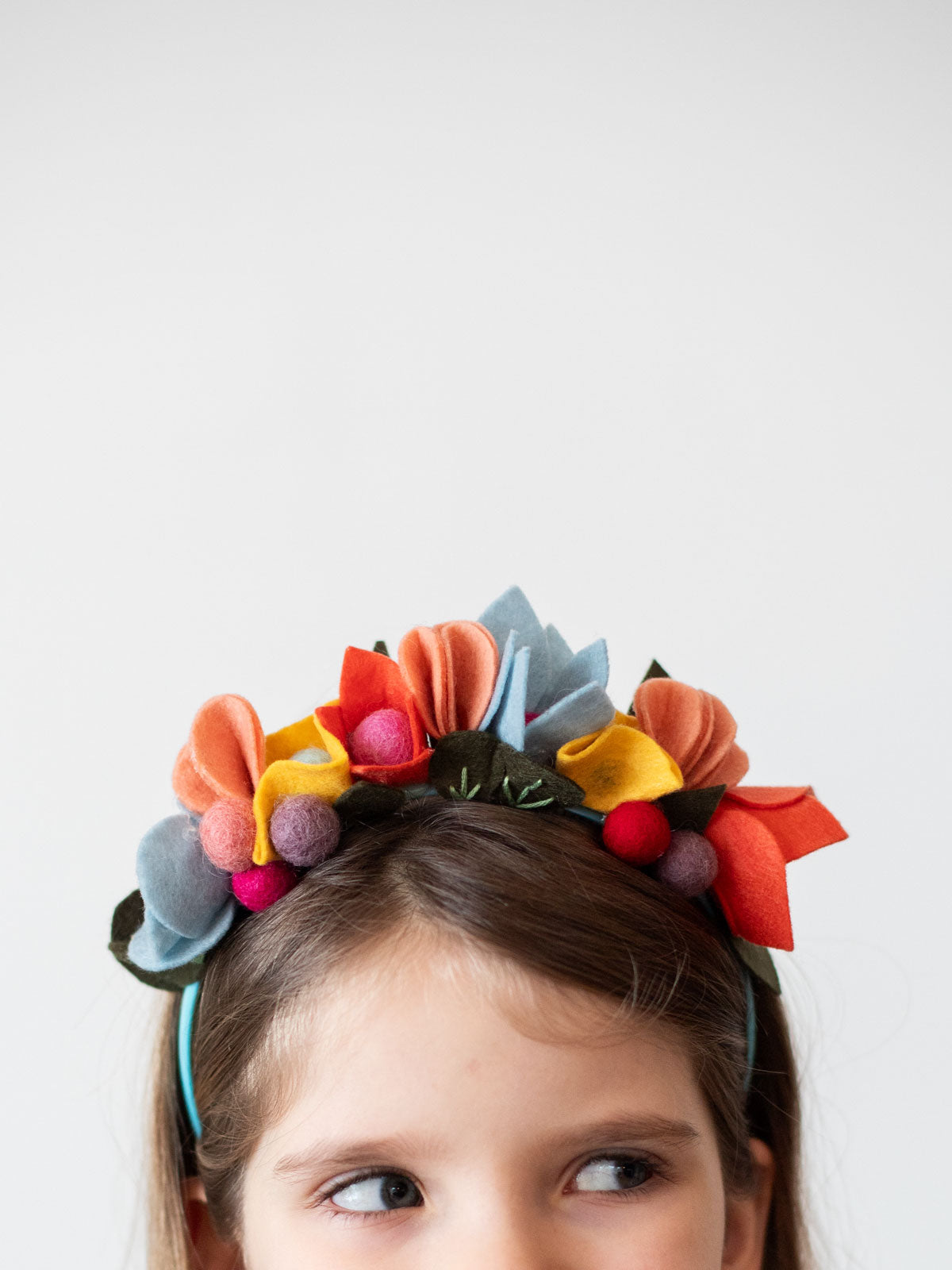 Kind mit Kopfschmuck aus Bastelfilz und Filzkugeln von Rico nach Bastelanleitung von Halfbird