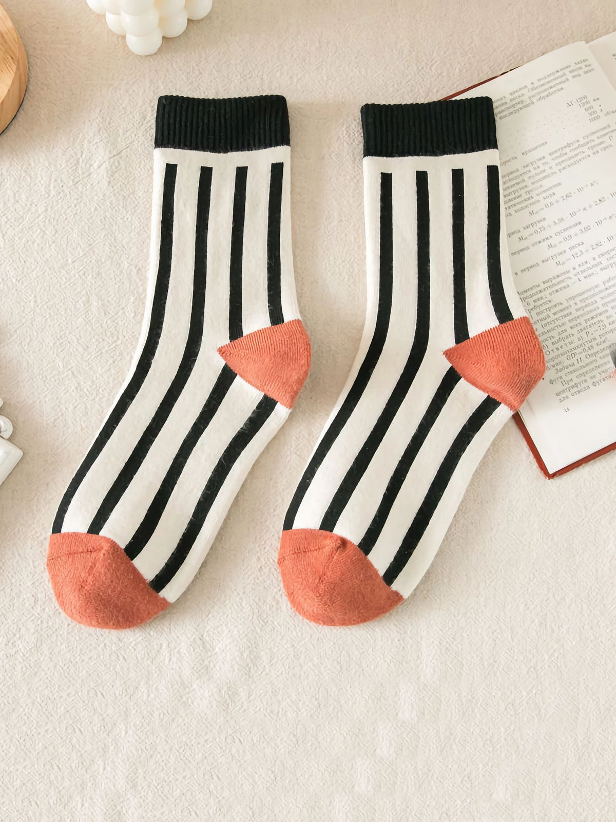 Socken in weiß mit schwarzen Streifen und Bündchen mit orangenem Zwickel und Ferse