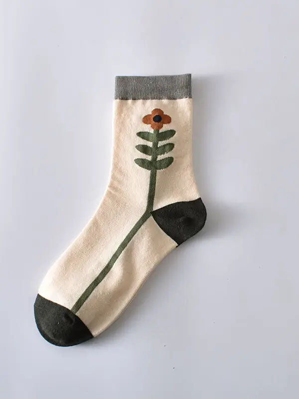weiße Socken mit einer grün-orangenen Blume, die den Fuß entlang rankt und grauem Bündchen