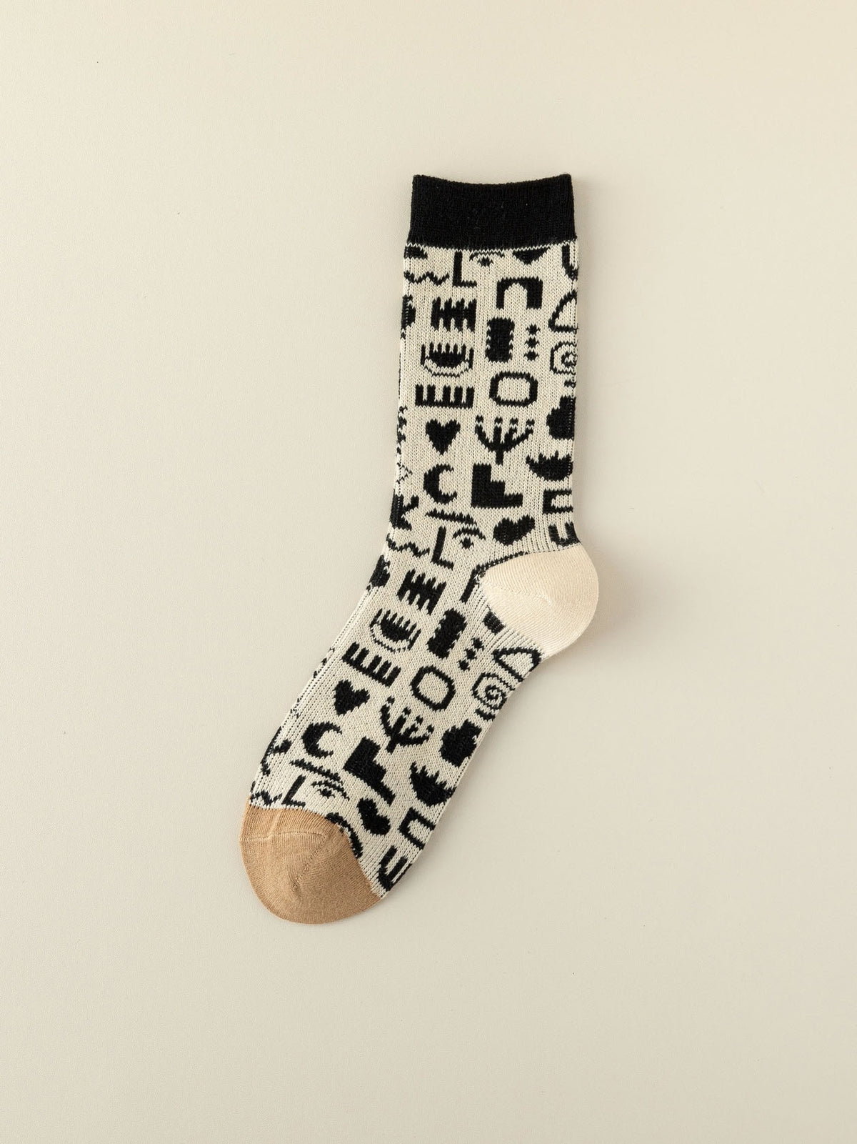 Socke mit Formen und Muster in schwarz und weiß mit beigem Zwickel und weißer Ferse
