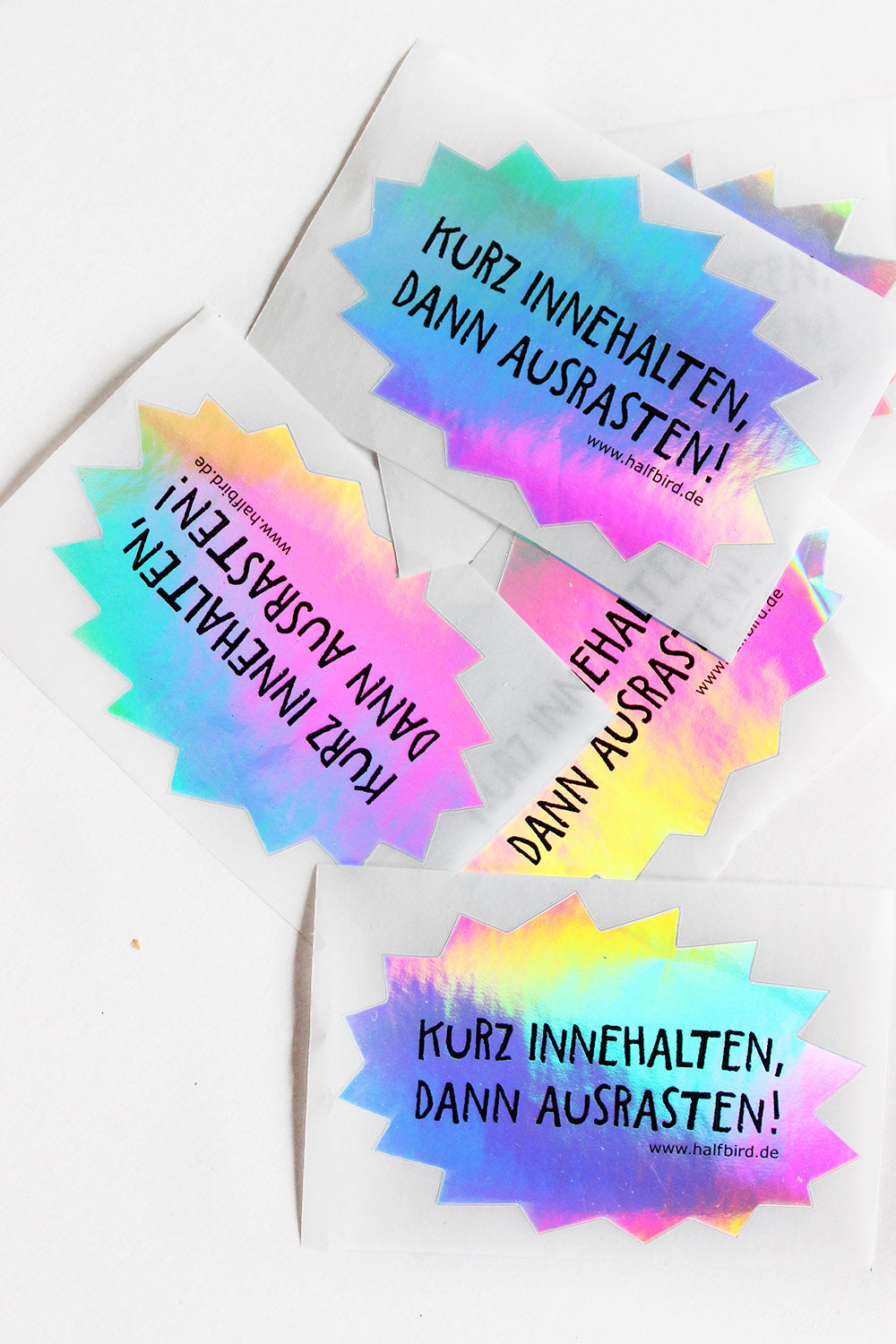 bild von mehreren hologramm stickern mit text kurz innehalten, dann ausrasten! von halfbird