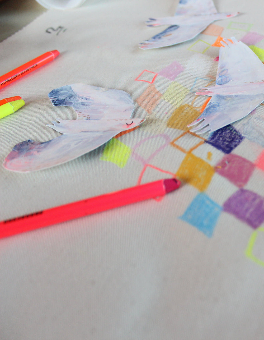 Neon Buntstifte neben bemalten Birdies von Halfbird