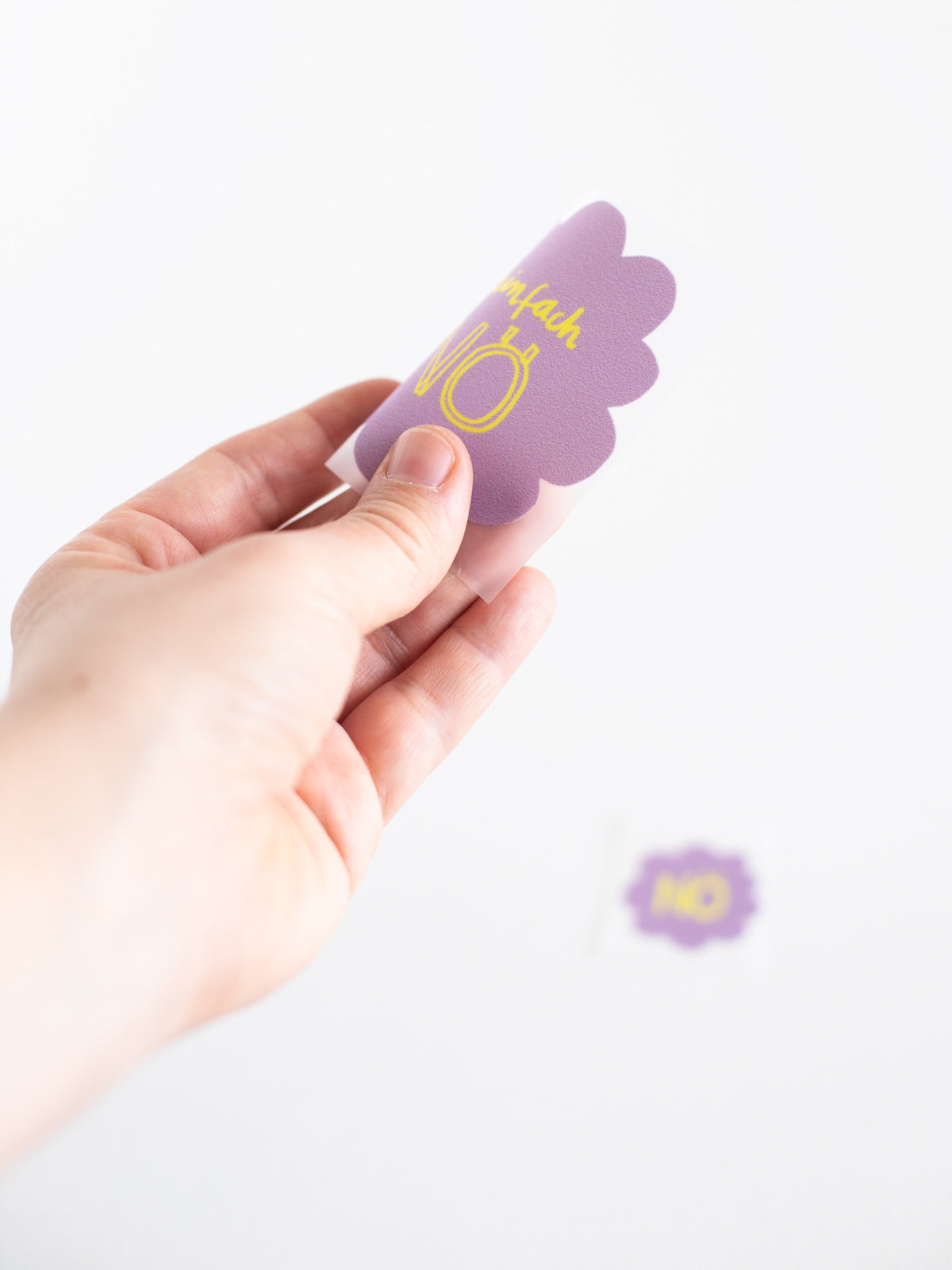 Hand mit dem großen Buegelbild aus dem Set Bügelbild randlos Nö in Flieder mit gelber Schrift von Halfbird