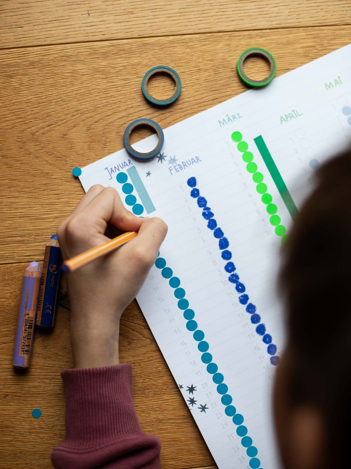 Kind bemalt Stickerkalender nach Montessori von Halfbird