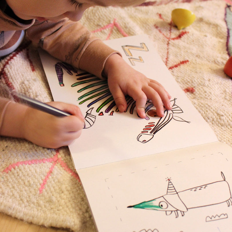 Kind malt Zebra im ABC Malbuch aus