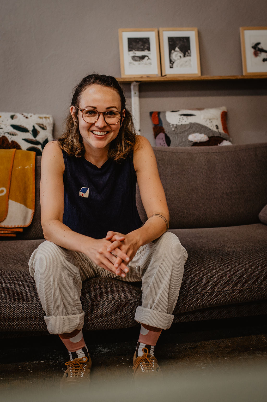 Potrait von Ramona Zirk in ihrem Atelier halfbird auf der couch