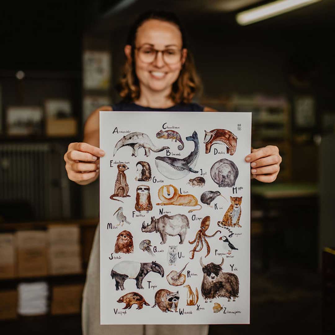 Frau hält ein ABC Tierposter in der Hand