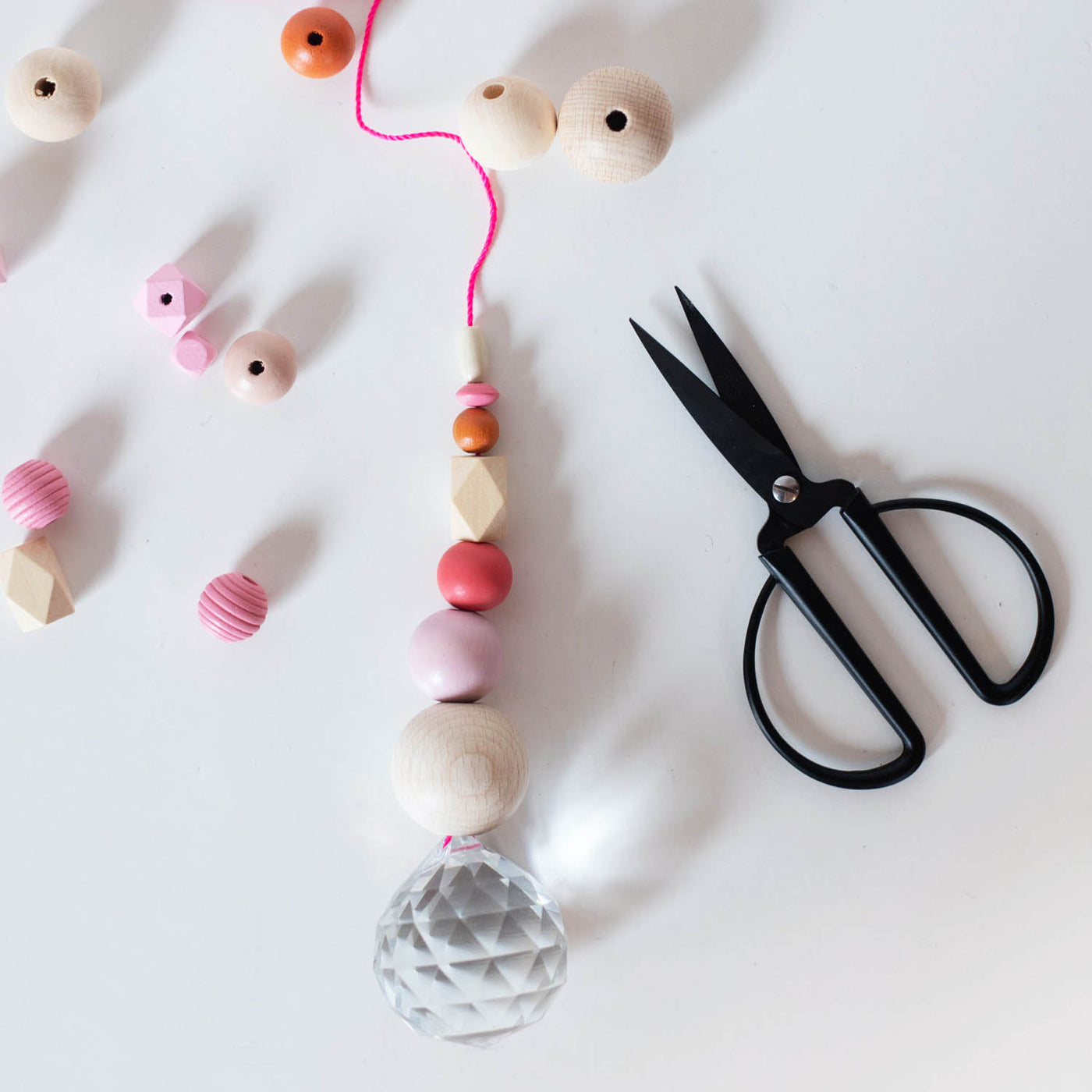 Sonnenfänger selbst basteln aus Holzperlen in pink mit Regenbogenkristallkugel