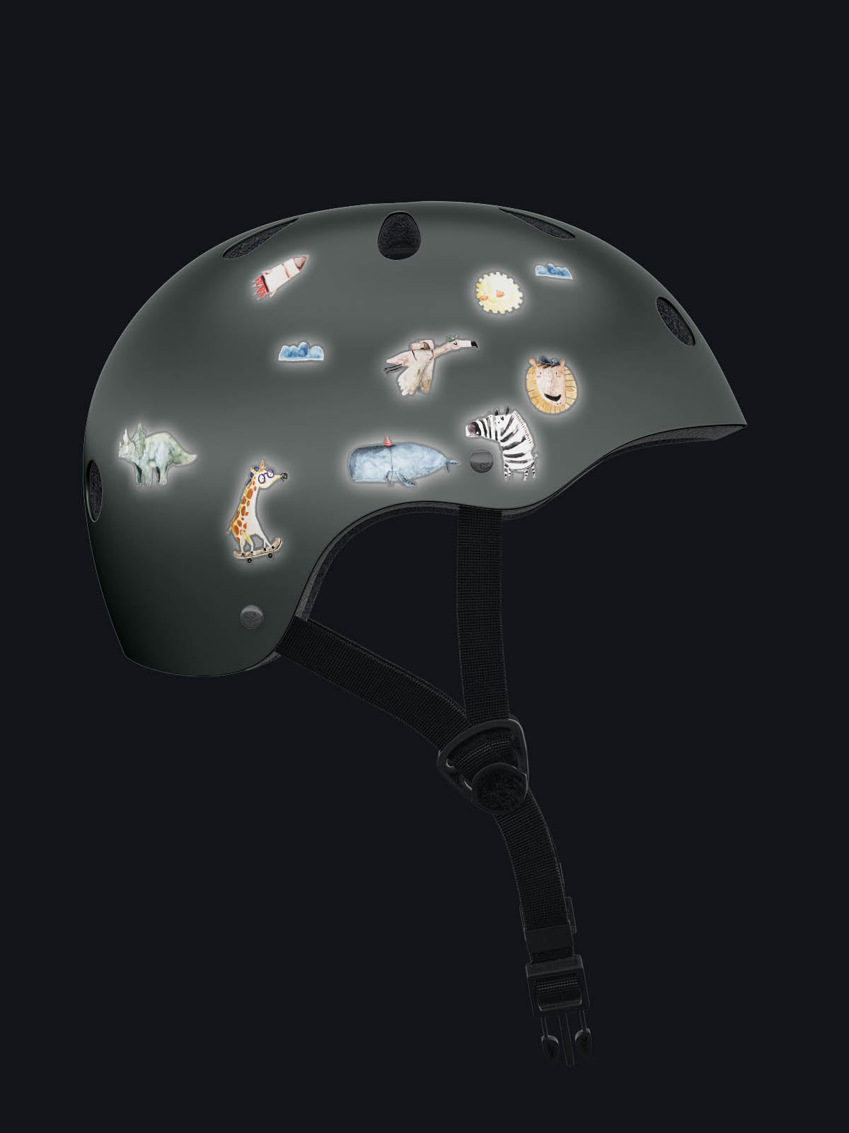 Fahrradhelm bei nacht mit reflektirenden aufkleber beklebt. dabei sind giraffe, zebra, wal, flamingo, dino, sonne, rakete, wolken löwe