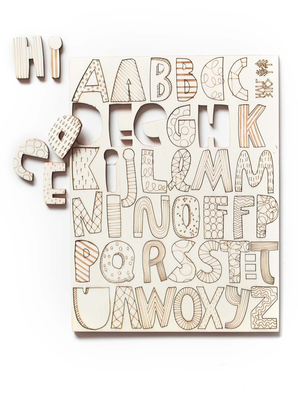 Holzbuchstaben Kinderzimmer gelasert in einem Tableau. einige Buchstaben sind aus dem Tableau ausgestanzt und liegen daneben