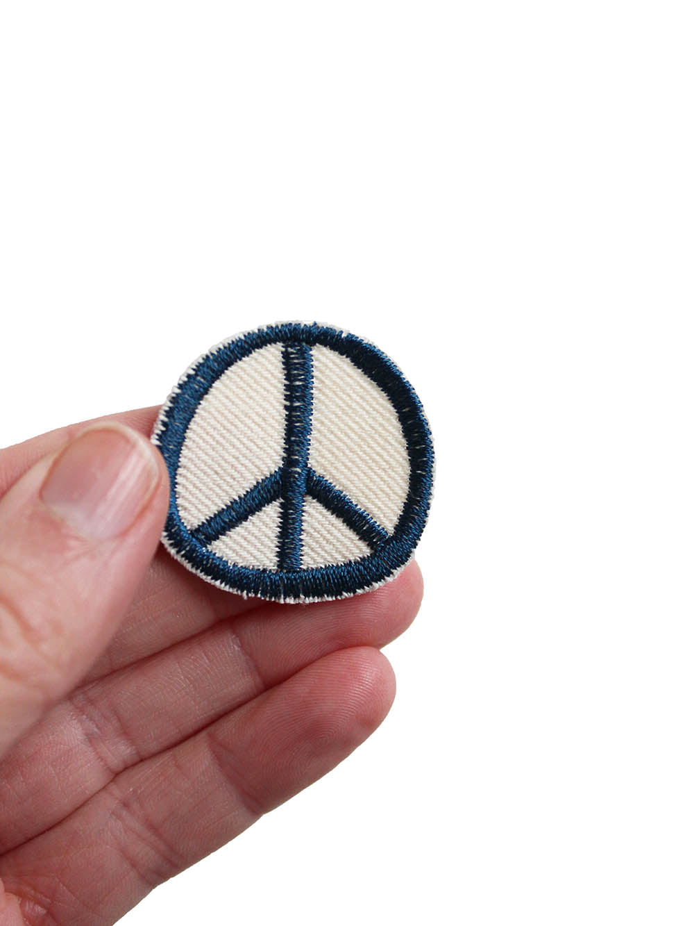 Peace Aufnäher rund in blau auf biobaumwolle in der Hand gehalten
