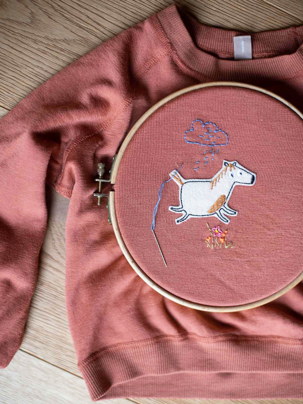 kaputter Pullover wird mit einem Bügelflicken Pferd von halfbird geflickt und mit Stickdetails verschönert