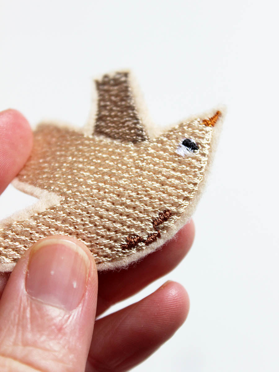 Detail des Vogel Aufnähers in beige mit braunen punkten