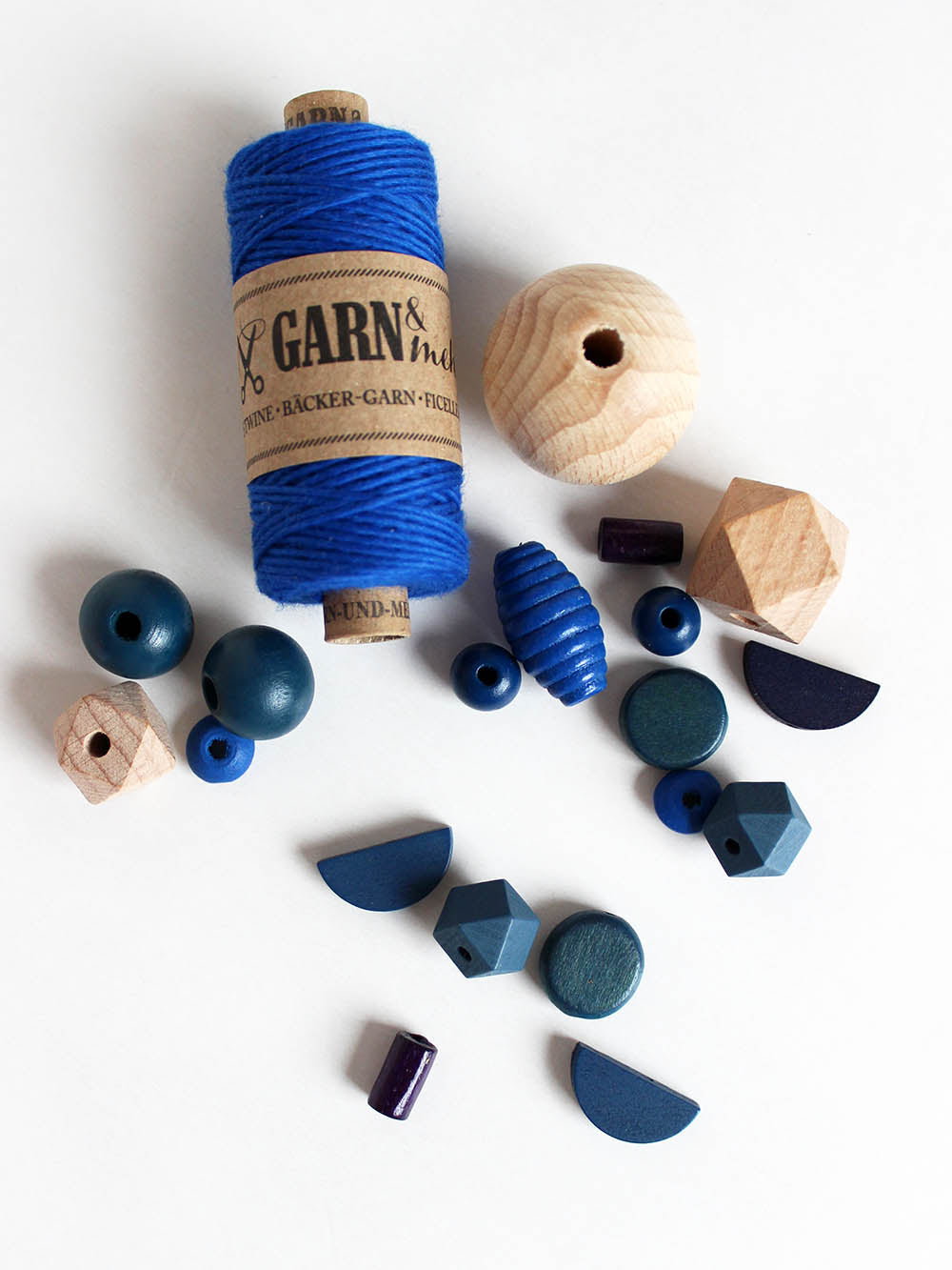 blaues Bäckergarn und schöne Perlen in blau, petrol und Holz als Kugel, halbmond und co.