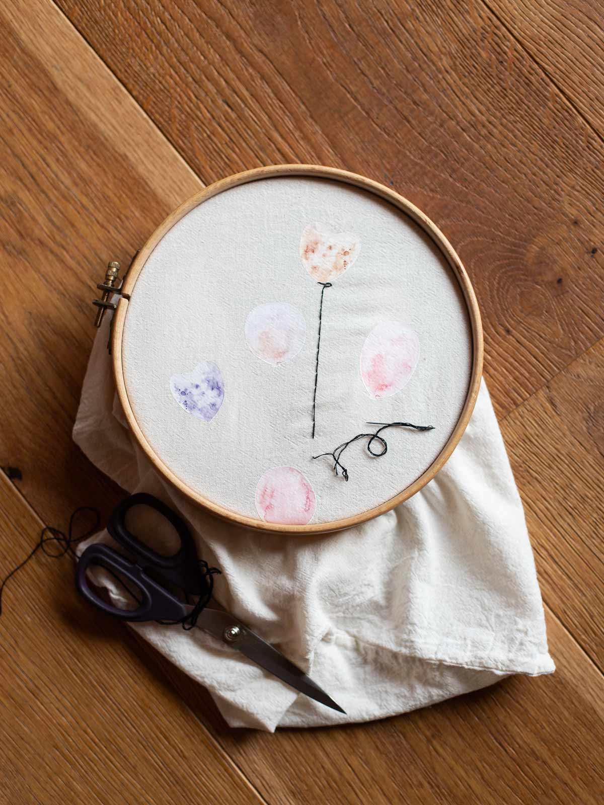 Stickrahmen mit Geschenkbeutel , auf dem das Bügelbild Set Luftballons mit aufgestickter Schnur zu sehen ist