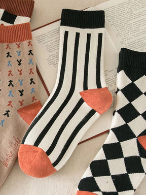 Nahansicht Socken in weiß mit schwarzen Streifen und Bündchen mit orangenem Zwickel und Ferse