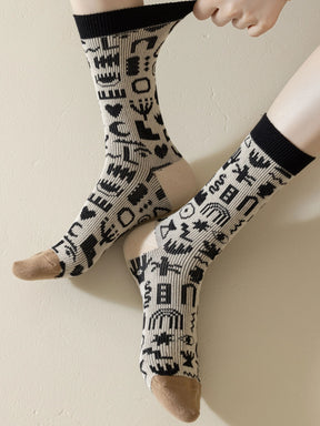 Trageansicht Socke mit Formen und Muster in schwarz und weiß mit beigem Zwickel und weißer Ferse