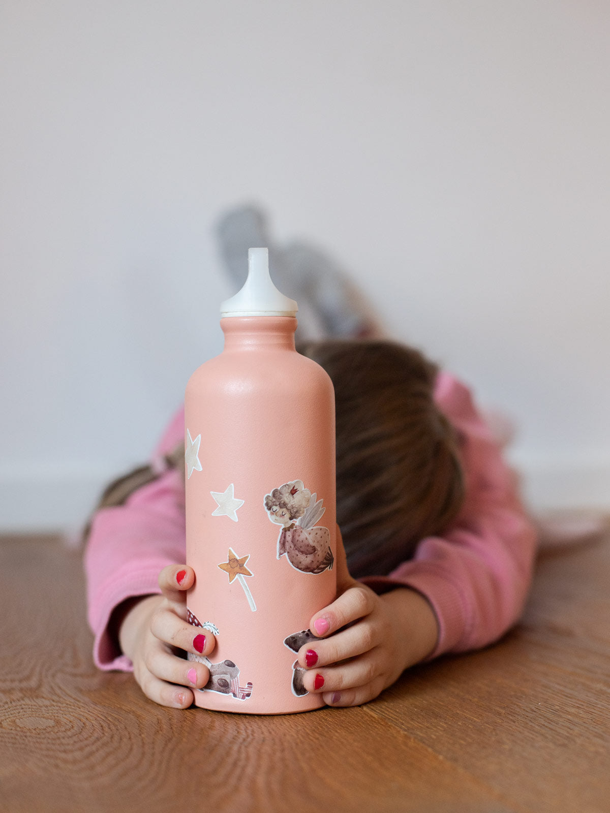 Kind hält eine apricot farbene Metall Trinkflasche vor sich und darauf sind feen sticker von halfbird in spülmaschinenfest