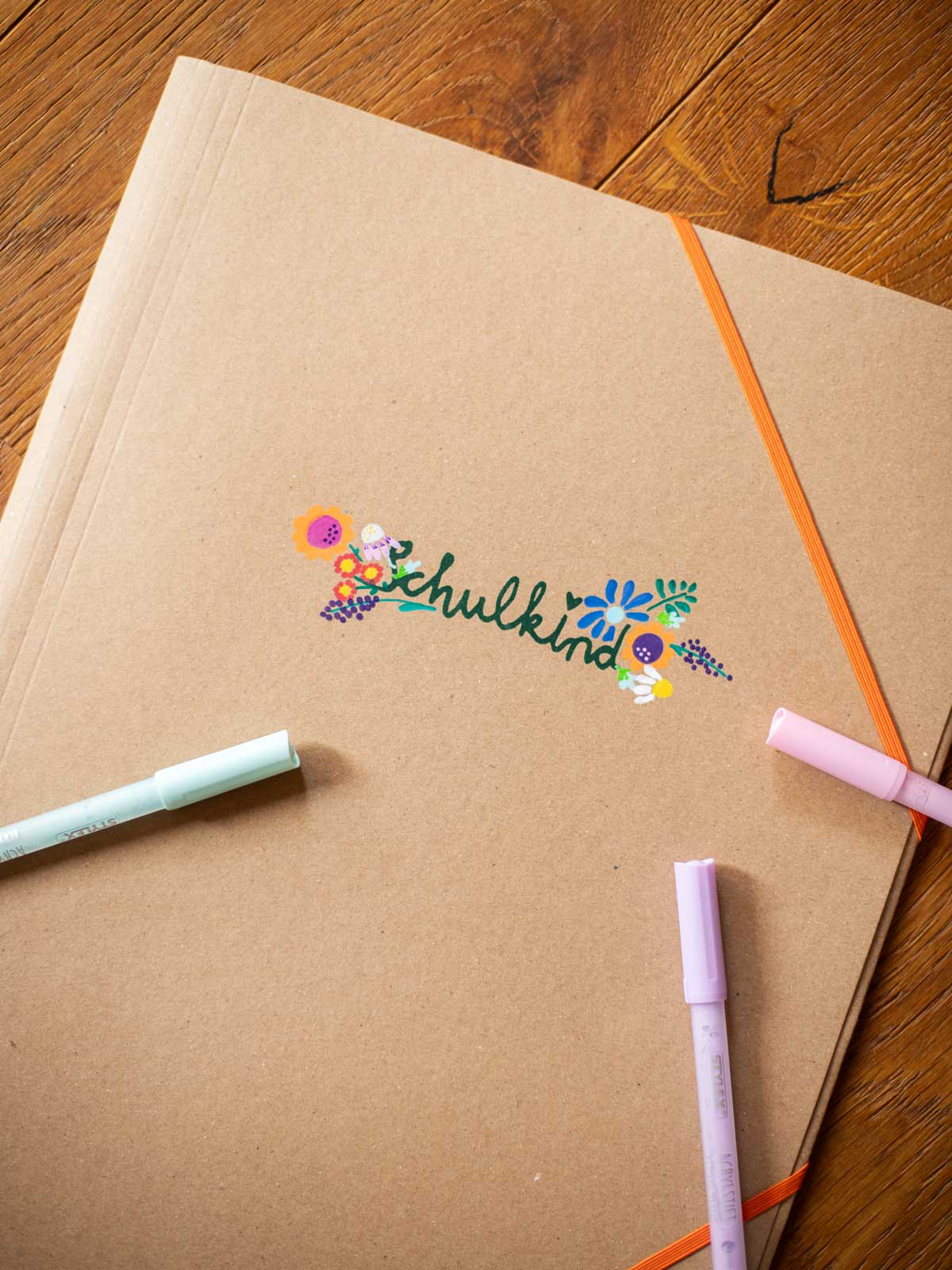 Postmappe mit Halfbird Schulkind-Motiv gesiebdruckt und mit Acrylstiften aufgemalten Blumen 