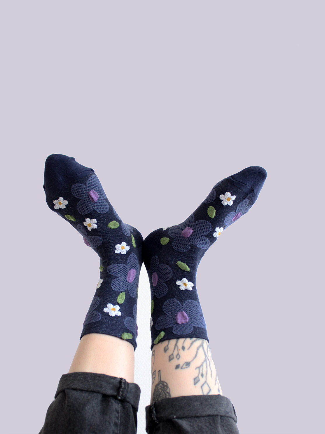 Tragebild von dunkelblauen Socken mit erhabener Struktur mit großen taubenblauen und weißen Blumen