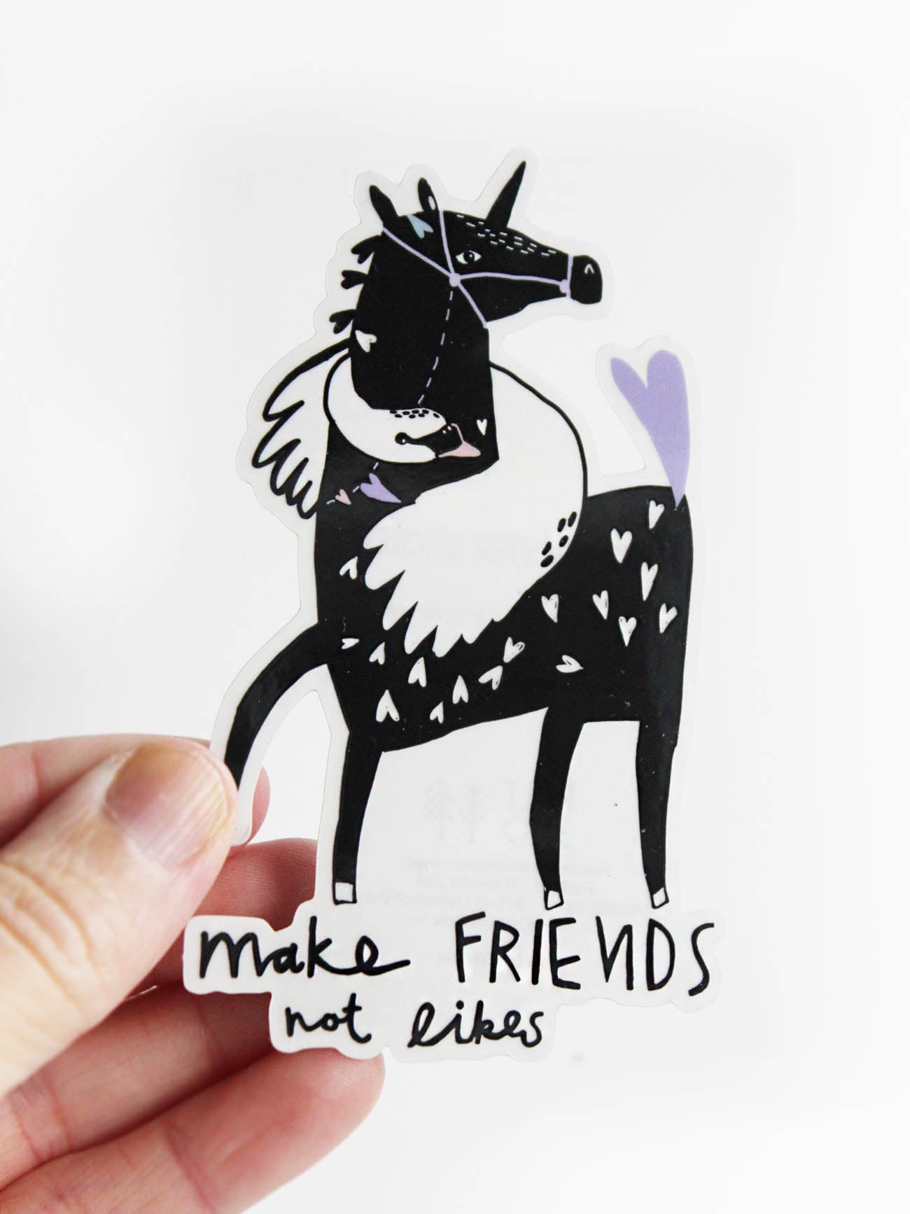 Hand mit transparenter Vinylsticker Make Friends not Likes mit Pferd- und Schwanmotiv von Halfbird