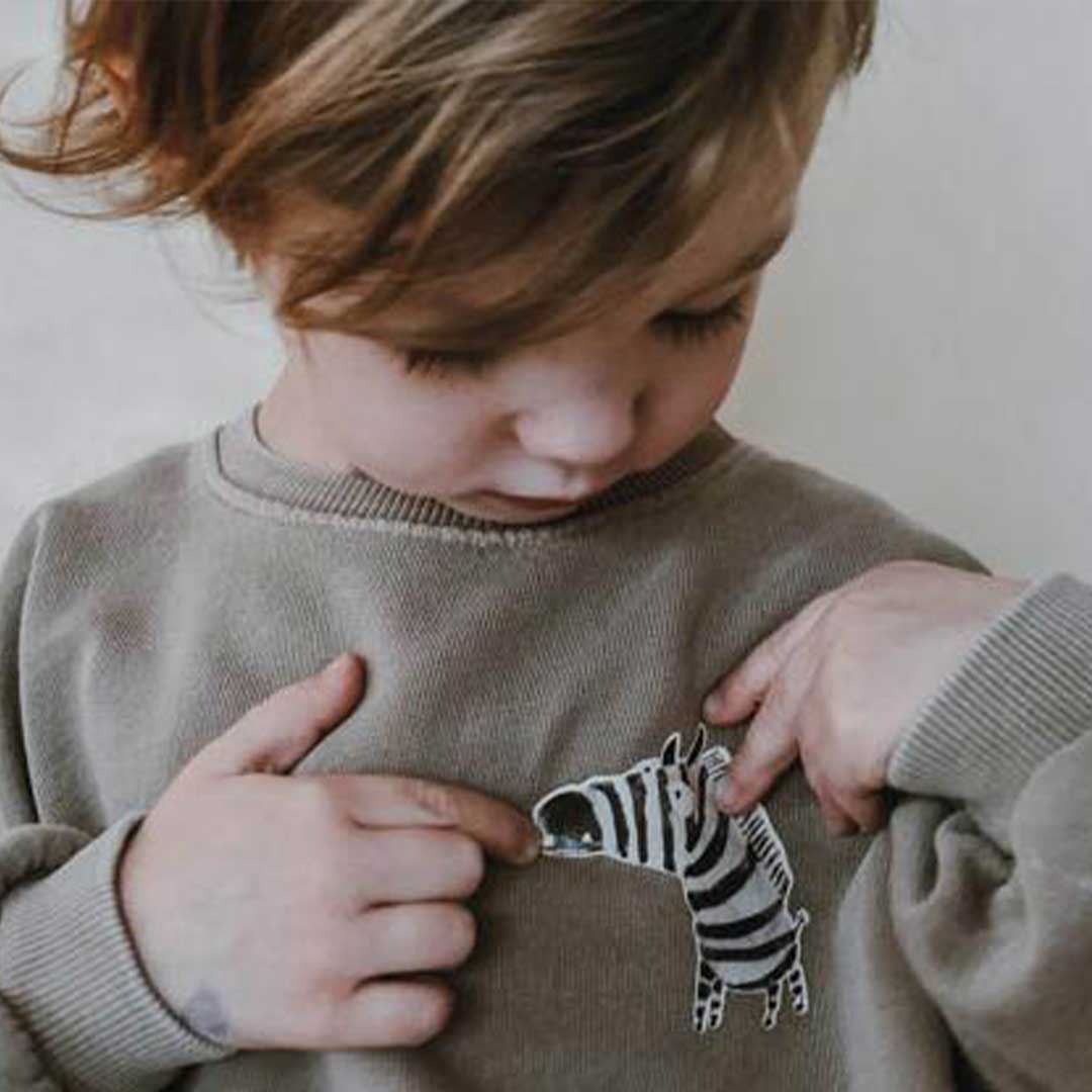Kind schaut sich Zebra Bügelbild an
