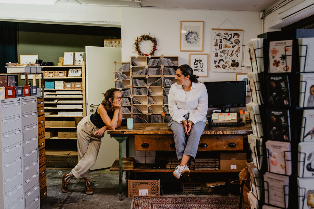 zwei Frauen unterhalten sich in ihrem Atelier miteinander