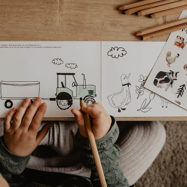Kind malt einen Traktor aus, der sich in der Verpackung der spülmaschinenfesten Bauernhof Sticker befindet
