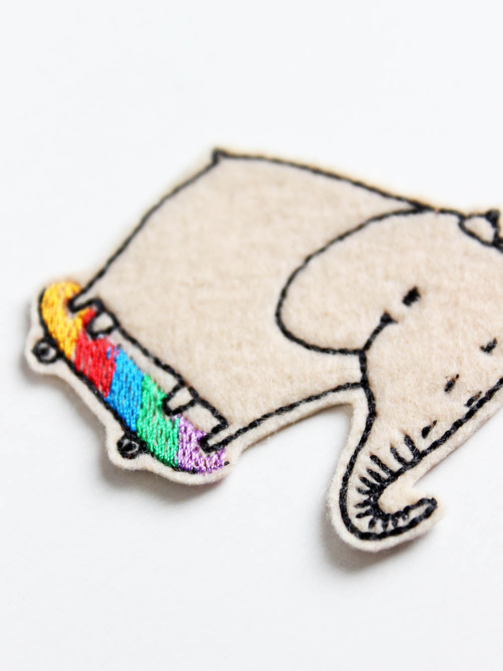 Detailansicht von einem Bügelflicken mit Elefant der Skateboard fährt, das Skateboard ist in Regenbogenfarben