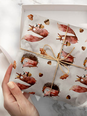 Geschenk eingepackt mit Geschenkpapier mit Eichhörnchen und Igel