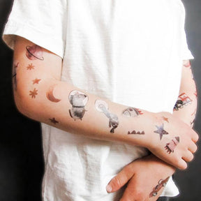 Kinderarm  mit Tattoos von halfbird und Nuukk. Kindertattoos mit Einhorn, Schildkröte und Gans im Weltall. Raketen, Sterne und Planeten