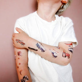 Kind mit veganen, temporären Tattoos von halfbird und Nuukk. Zu sehen sind Fahrzeuge aller Art