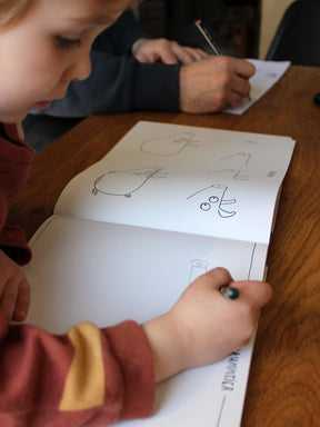 Kind lernt mit 3 Jahren ganz einfach das Malen mit diesem Krummtierbuch. Es malt ein Schwein