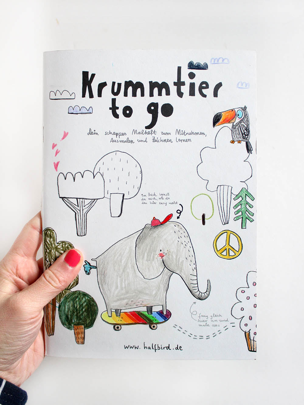 asugemaltes Cover vom Malbuch krummtier to go mit Elefant auf regenbogen skateboard, Tukan und Bäumen