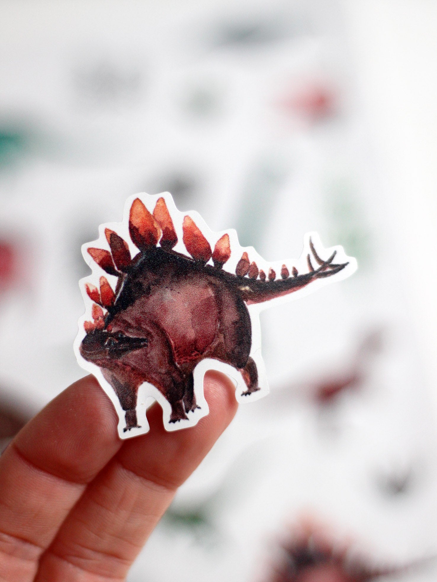 Stegosaurus als spülmaschinenfester Aufkleber auf der Hand von halfbird